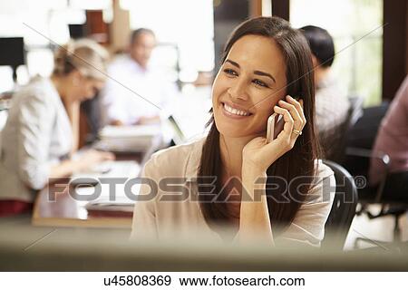 Businesswoman Working At Desk Using Mobile Phone View Large Photo Image Stock Photo - Businesswoman Working At Desk Using Mobile Phone. Fotosearch
