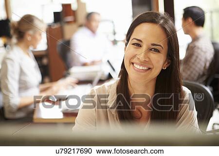 Businesswoman Working At Desk With Meeting In Background View Large Photo Image Stock Image - Businesswoman Working At Desk With Meeting In Background. Fotosearch