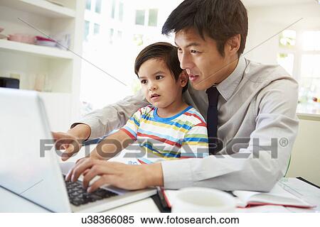 Stock Photography - Busy Father Working From Home With Son. Fotosearch