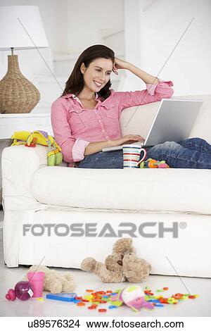 Busy mother working on laptop View Large Photo Image Picture - Busy mother working on laptop. Fotosearch
