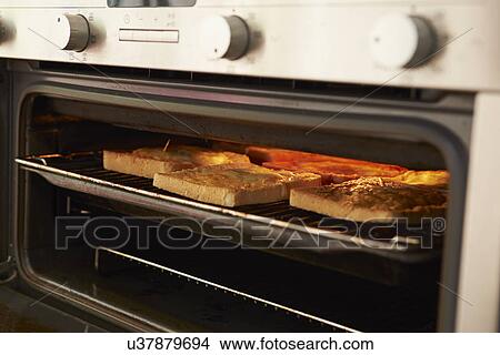 Picture - Cheese On Toast Being Grilled In Oven. Fotosearch