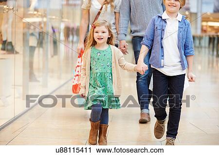 Stock Image - Children On Trip To Shopping Mall With Parents. Fotosearch