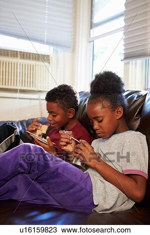 Children With Poor Diet Eating Meal On Sofa At Home View Large Photo Image Stock Image - Children With Poor Diet Eating Meal On Sofa At Home. Fotosearch