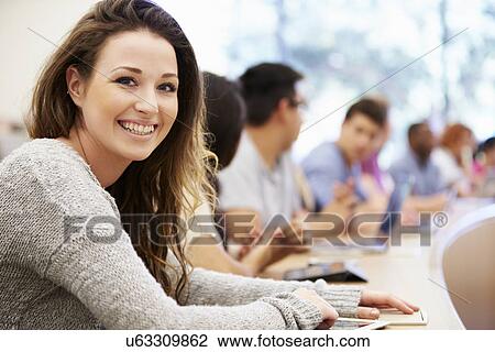 Stock Image - Class Of University Students Using Laptops In Lecture. Fotosearch