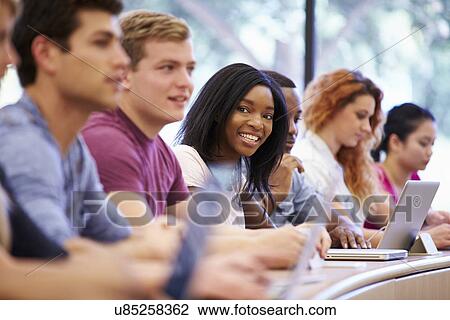 Stock Image - Class Of University Students Using Laptops In Lecture. Fotosearch