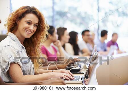 Stock Image - Class Of University Students Using Laptops In Lecture. Fotosearch
