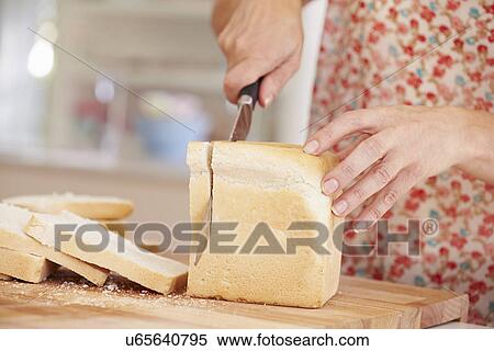 Close Up Of Woman Slicing Loaf Of Bread In Kitchen View Large Photo Image Stock Photography - Close Up Of Woman Slicing Loaf Of Bread In Kitchen. Fotosearch