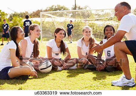 Stock Photo - Coach Giving Team Talk To Female High School Soccer Team. Fotosearch