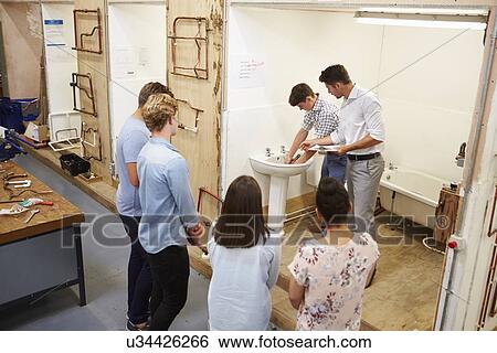 Stock Photograph - College Students Studying Plumbing Working On Washbasin. Fotosearch