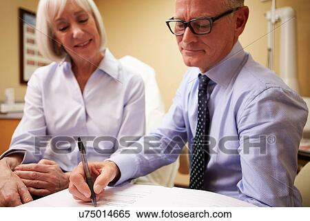 Stock Photography - Cosmetic Surgeon Discussing Proceedure With Client In Office. Fotosearch