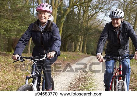 Couple Cycling Along Urban Street Together View Large Photo Image Stock Image - Couple Cycling Along Urban Street Together. Fotosearch