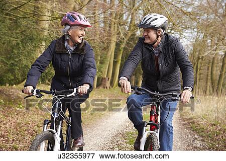 Stock Photo - Couple Cycling Along Urban Street Together. Fotosearch