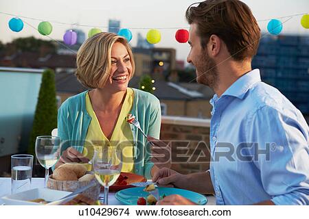 Couple Eating Evening Meal On Rooftop Terrace View Large Photo Image Picture - Couple Eating Evening Meal On Rooftop Terrace. Fotosearch