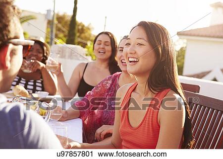 Stock Image - Couple Enjoying Outdoor Summer Meal With Friends. Fotosearch