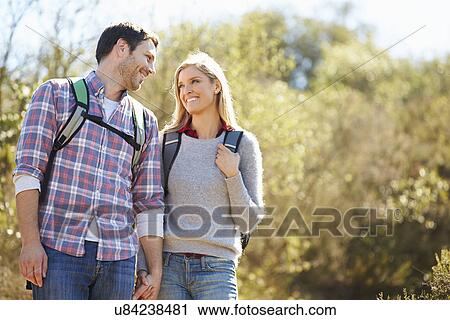 Couple Hiking In Countryside Wearing Backpacks View Large Photo Image Stock Image - Couple Hiking In Countryside Wearing Backpacks. Fotosearch