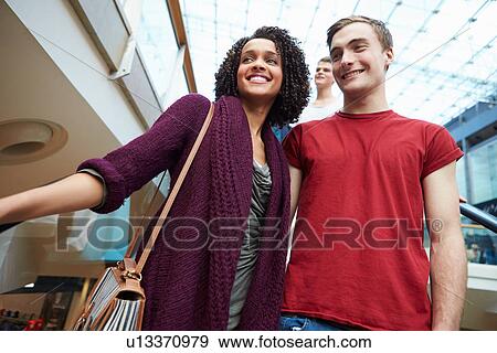 Couple On Escalator In Shopping Mall Together View Large Photo Image Stock Photo - Couple On Escalator In Shopping Mall Together. Fotosearch