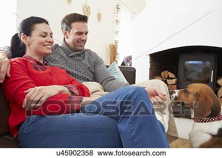 Stock Photo - Couple Relaxing At Home With Pet Dog. Fotosearch