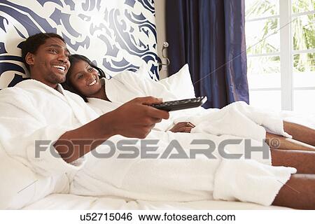 Couple Relaxing In Hotel Room Watching Television View Large Photo Image Stock Photograph - Couple Relaxing In Hotel Room Watching Television. Fotosearch