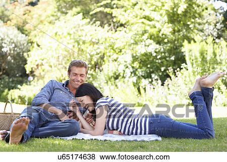 Couple relaxing in park View Large Photo Image Stock Photo - Couple relaxing in park. Fotosearch
