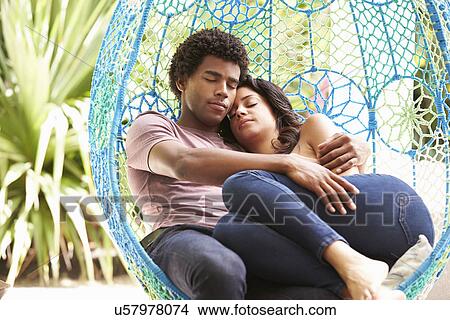 Picture - Couple Relaxing On Outdoor Garden Swing Seat. Fotosearch