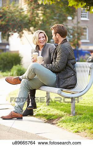Couple Relaxing On Park Bench With Takeaway Coffee View Large Photo Image Picture - Couple Relaxing On Park Bench With Takeaway Coffee. Fotosearch