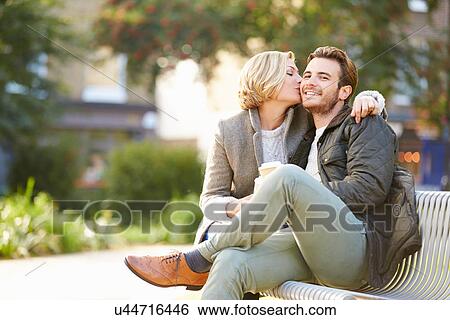 Couple Relaxing On Park Bench With Takeaway Coffee View Large Photo Image Stock Photograph - Couple Relaxing On Park Bench With Takeaway Coffee. Fotosearch