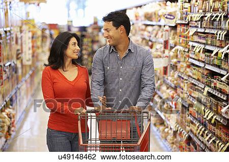 Stock Image - Couple shopping in supermarket. Fotosearch
