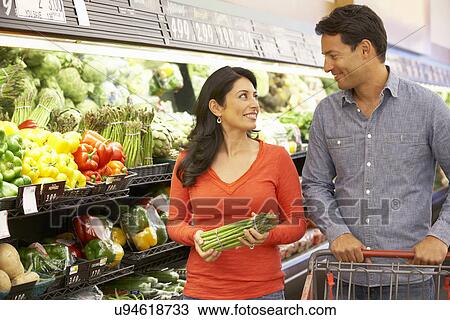 Stock Image - Couple shopping in supermarket. Fotosearch