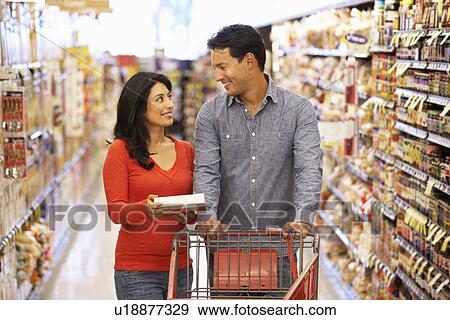 Couple shopping in supermarket View Large Photo Image Stock Photo - Couple shopping in supermarket. Fotosearch