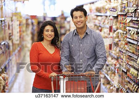 Couple shopping in supermarket View Large Photo Image Stock Photo - Couple shopping in supermarket. Fotosearch