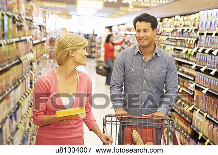Couple shopping in supermarket View Large Photo Image Stock Photo - Couple shopping in supermarket. Fotosearch