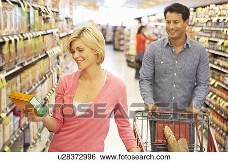Couple shopping in supermarket View Large Photo Image Stock Photograph - Couple shopping in supermarket. Fotosearch