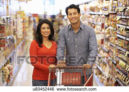 Couple shopping in supermarket View Large Photo Image Stock Photograph - Couple shopping in supermarket. Fotosearch