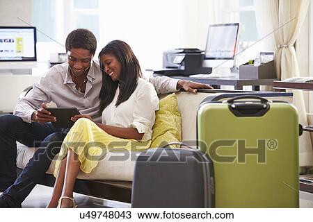 Couple Sitting In Hotel Lobby Looking At Digital Tablet View Large Photo Image Stock Image - Couple Sitting In Hotel Lobby Looking At Digital Tablet. Fotosearch