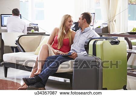 Couple Sitting In Hotel Lobby With Luggage View Large Photo Image Stock Photo - Couple Sitting In Hotel Lobby With Luggage. Fotosearch