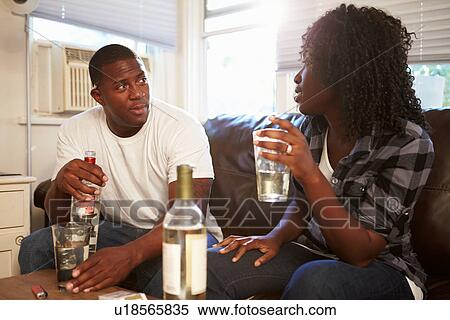 Couple Sitting On Sofa Drinking Alcohol And Arguing View Large Photo Image Stock Photography - Couple Sitting On Sofa Drinking Alcohol And Arguing. Fotosearch