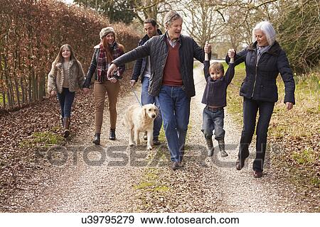 Stock Photo - Couple Taking Dog For Walk On City Street. Fotosearch