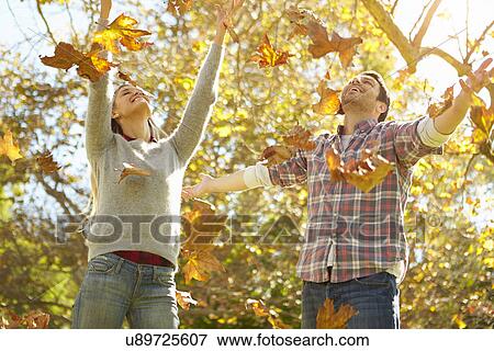 Couple Throwing Autumn Leaves In The Air View Large Photo Image Stock Photo - Couple Throwing Autumn Leaves In The Air. Fotosearch
