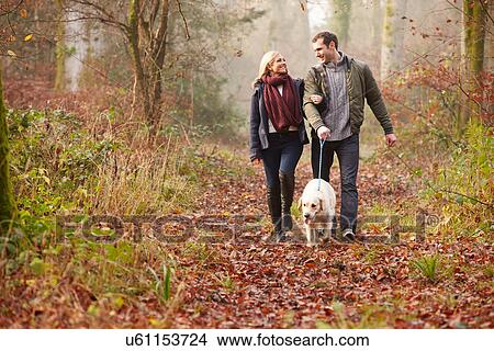 Couple Walking Dog Through Winter Woodland View Large Photo Image Picture - Couple Walking Dog Through Winter Woodland. Fotosearch