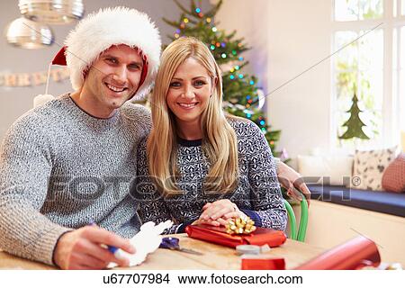 Couple Wrapping Christmas Gifts At Home View Large Photo Image Picture - Couple Wrapping Christmas Gifts At Home. Fotosearch