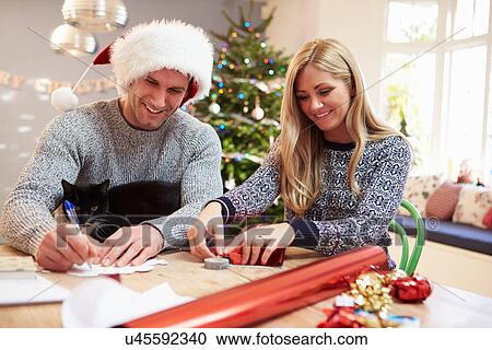 Couple Wrapping Christmas Gifts At Home View Large Photo Image Stock Image - Couple Wrapping Christmas Gifts At Home. Fotosearch