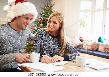 Stock Image - Couple Writing Christmas Cards Together. Fotosearch