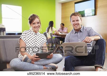 Picture - Creatives Having Informal Meeting On Sofas In Design Studio. Fotosearch