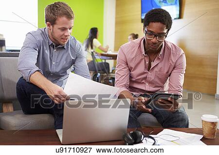 Stock Photo - Creatives Having Informal Meeting On Sofas In Design Studio. Fotosearch