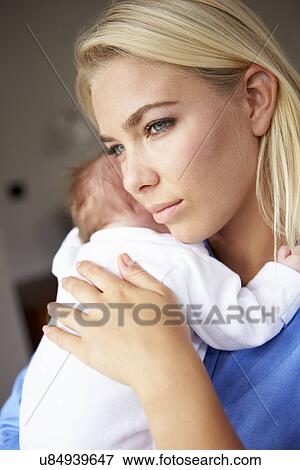 Stock Photo - Depressed Mother Cuddling Newborn Baby. Fotosearch