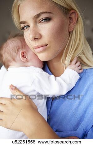 Stock Photograph - Depressed Mother Cuddling Newborn Baby. Fotosearch