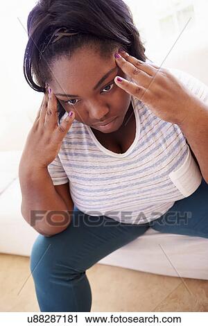 Stock Image - Depressed Overweight Woman Sitting On Sofa. Fotosearch