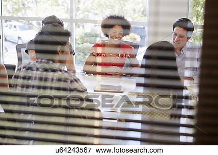 Stock Photo - Designers Having Meeting Viewed Through Window. Fotosearch