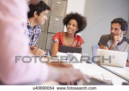 Picture - Designers Meeting To Discuss New Ideas. Fotosearch