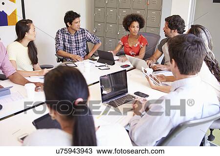Stock Image - Designers Meeting To Discuss New Ideas. Fotosearch